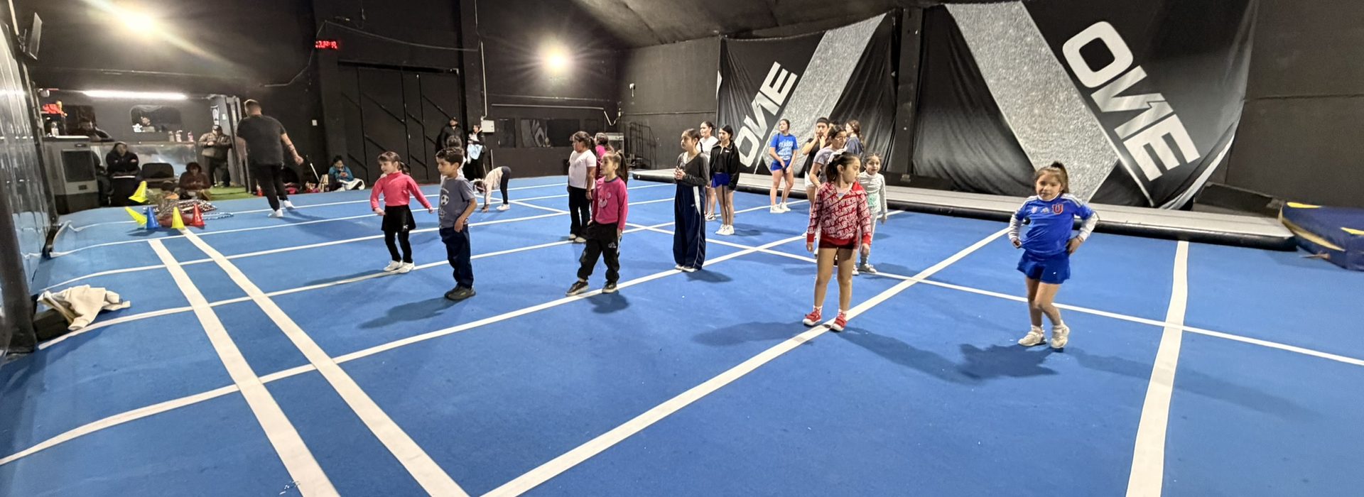 Niñas y niños llegando al gimnasio antes de empezar el entrenamiento