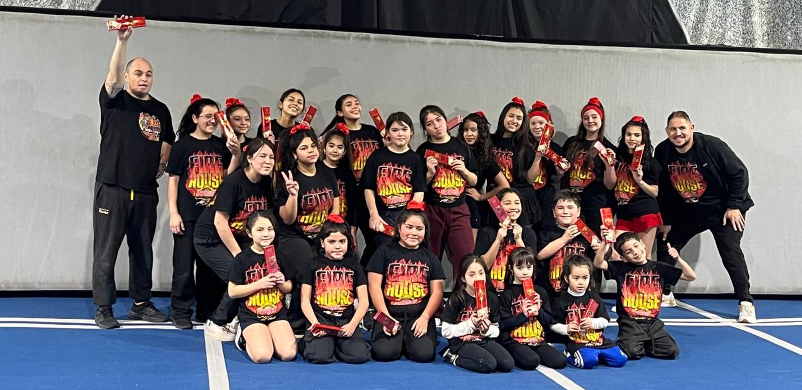 El plantel completo de Firehouse Cheer con sus entrenadores en el gimnasio