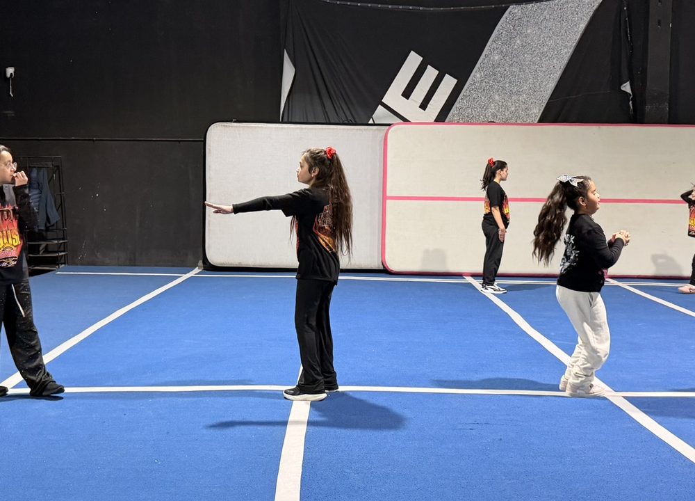 Deportistas de Firehouse practicando motions en fila durante la Cheer Class